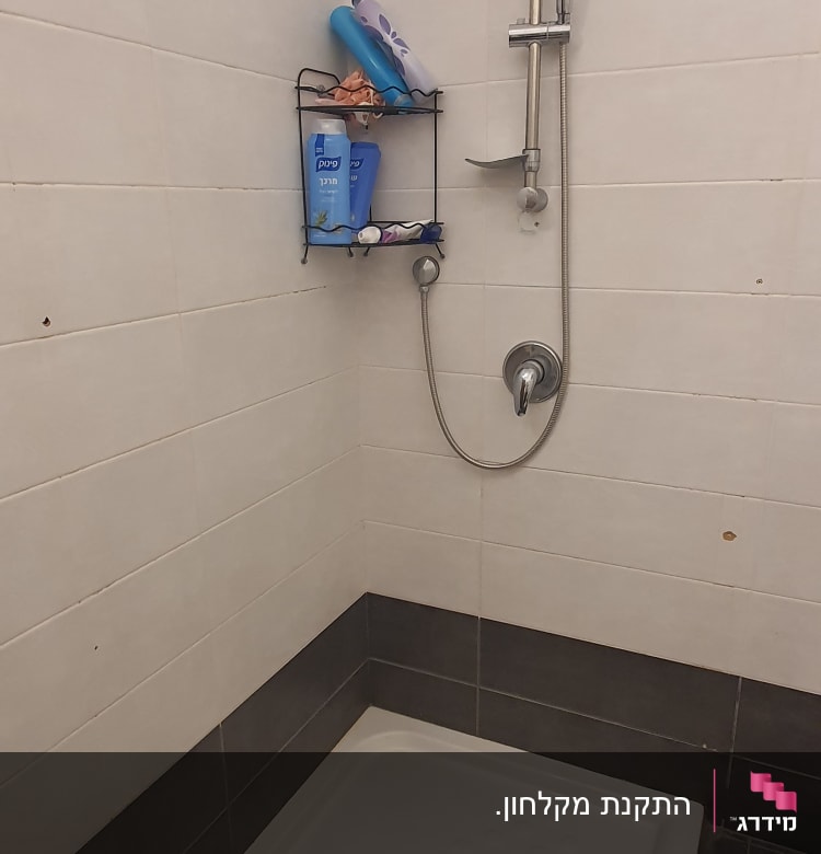 מקלחת עם ראש מקלחת ומדף עם מוצרי רחצה